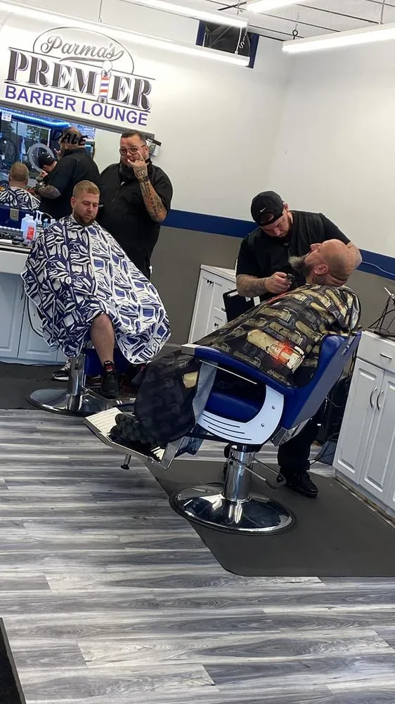 Barbers working on clients inside Parma Premier Barber Lounge.