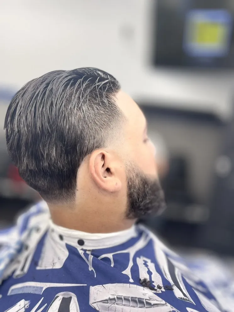 Slicked back taper with clean beard line at the lounge.