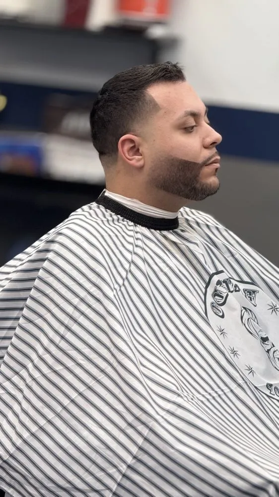 Side profile showing clean beard lineup and fade.