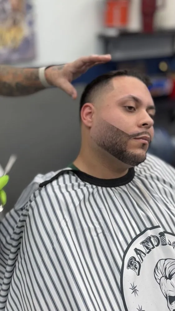 Low taper fade with styled top at Parma barbershop.